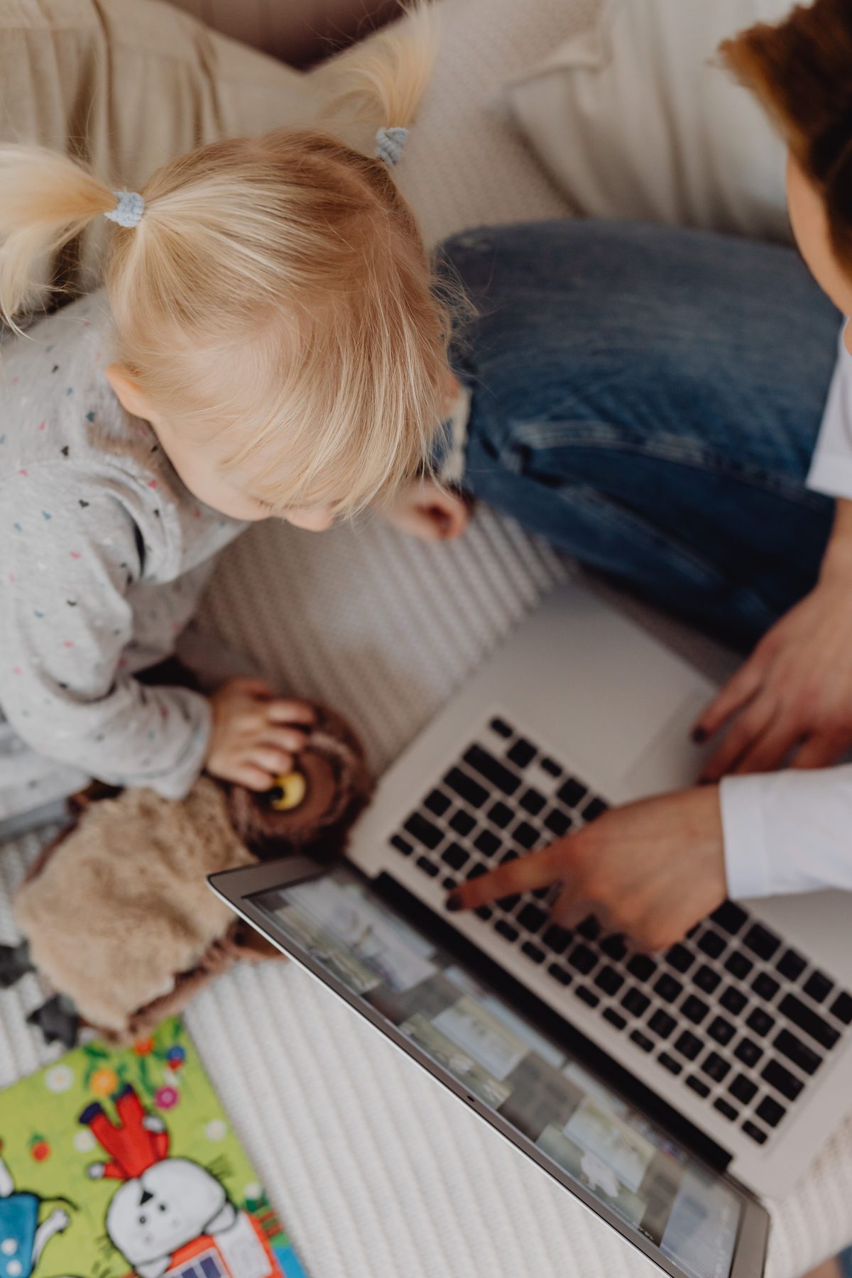 Une mère et son enfant sur un canapé avec un ordinateur portable
